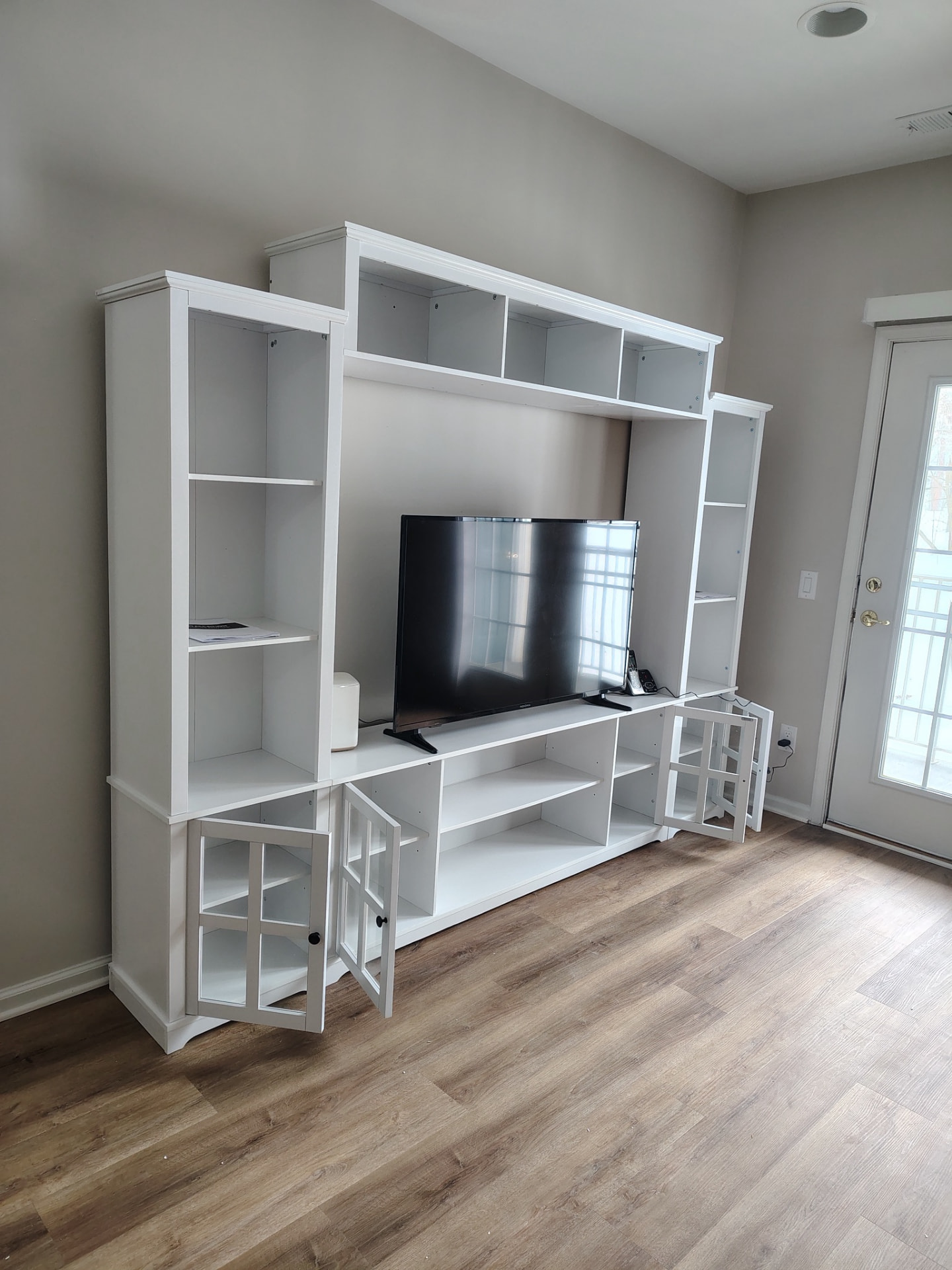 White media shelving unit with a television in a living room.